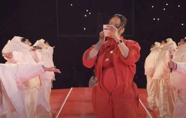 Rihanna applying fenty beauty powder at the super bowl half time show